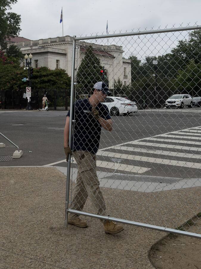Worker wearing Rawhide cargo pants carrying a fence panel